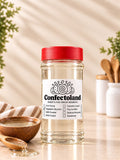 A clear glass jar of Confectoland vegetable glycerin with a bright red lid and a white label, set on a light beige surface with a wooden spoon, vegetable glycerin, and kitchen utensils in the background.